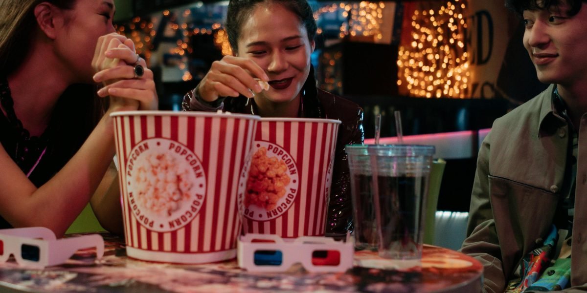 Friends or family members happily watching a movie together, enjoying the experience.