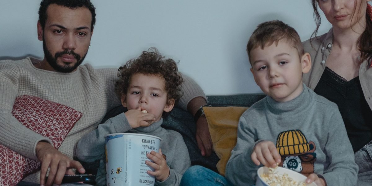 A family watching a movie together, sharing a moment of entertainment.